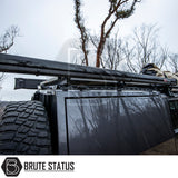 Close-up of a dark 4WD with a Brute Status roof rack, ARB Aluminium Case Awning & LED Light Kit, and mounted spare tire.