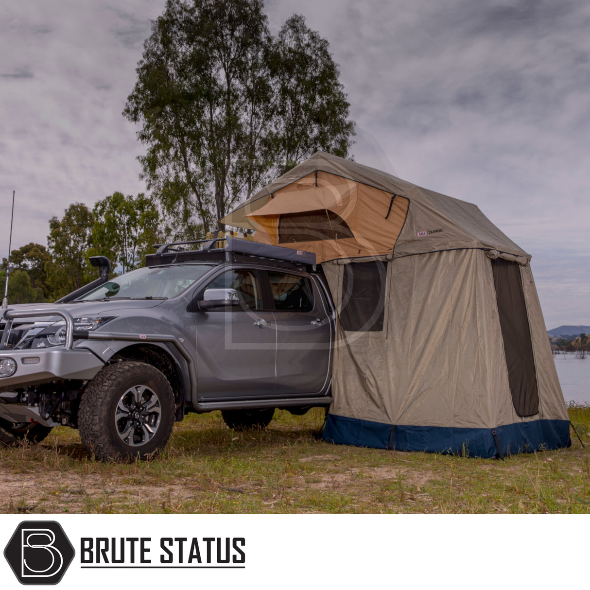 Pickup truck with ARB Simpson III Rooftop Tent and Annex parked lakeside, showcasing a robust camping setup ideal for adventurous outdoor enthusiasts.