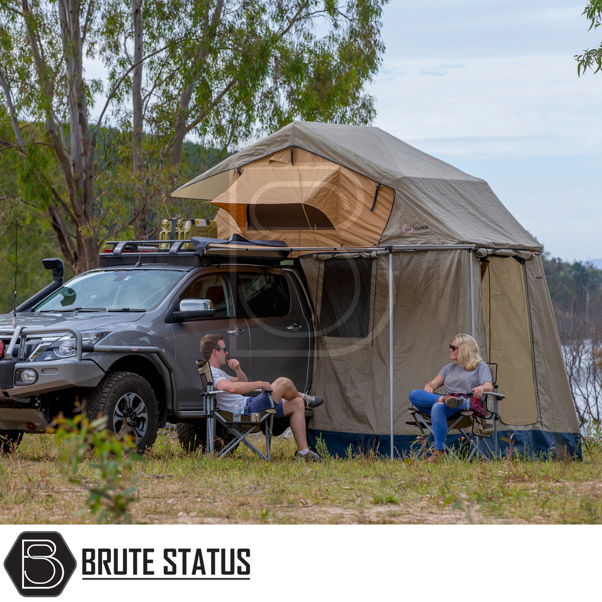 ARB Simpson III Rooftop Tent & Annex on pickup, unfolded beside campers in bushland, showcasing off-ground sleeping space with annex for extra protection.