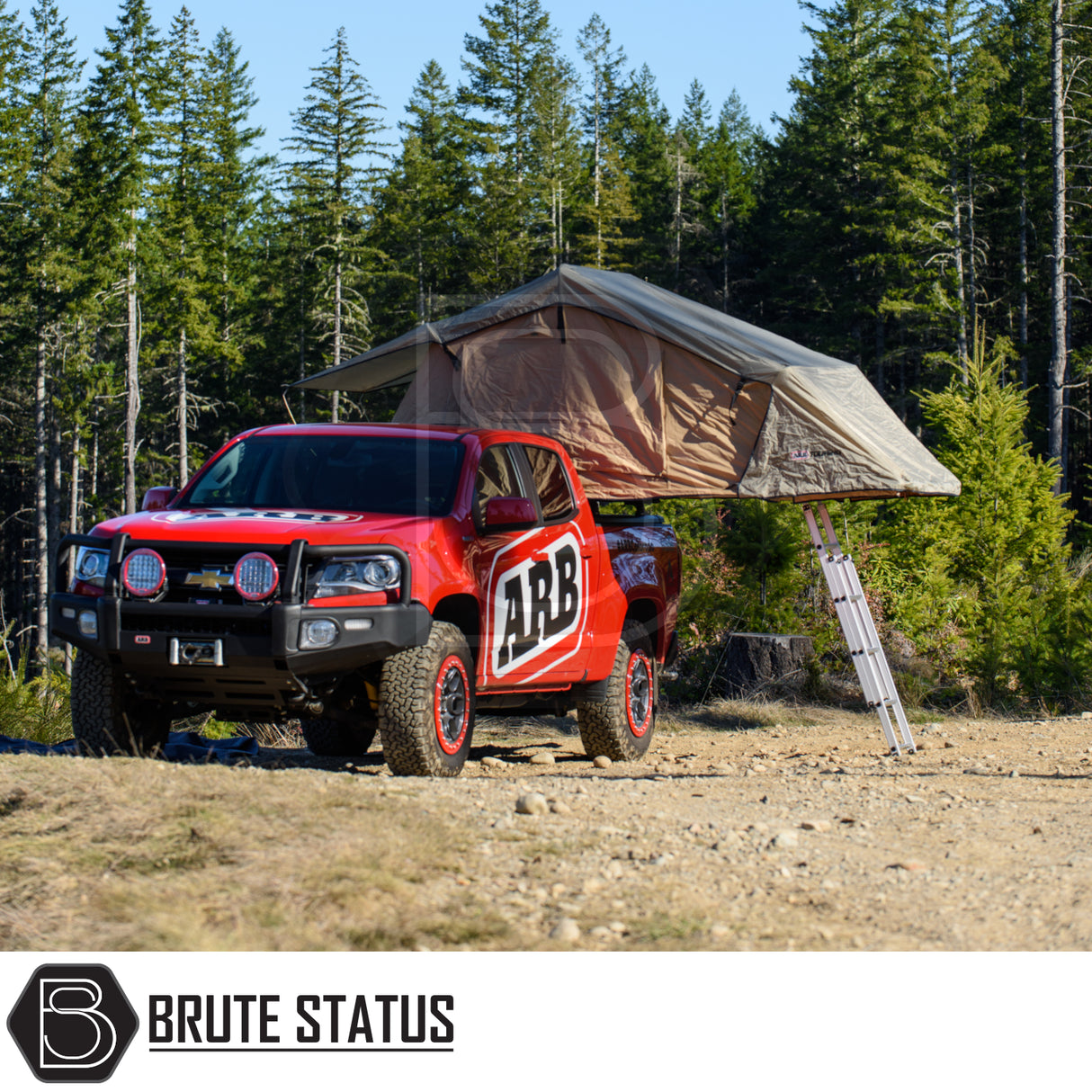 Chevrolet pickup with ARB Simpson III Rooftop Tent, featuring a fold-out design with telescoping ladder, set in a forest backdrop.