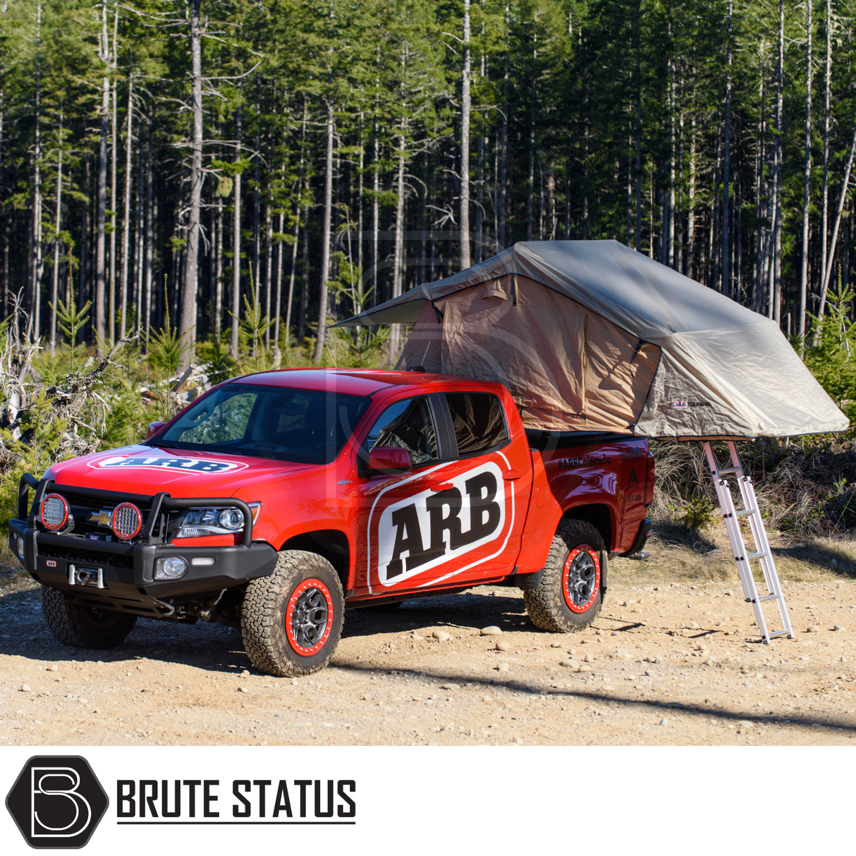 ARB Simpson III Rooftop Tent on a red ARB pickup, equipped with off-road features, parked near a forest, showcasing adventure-ready camping capabilities.