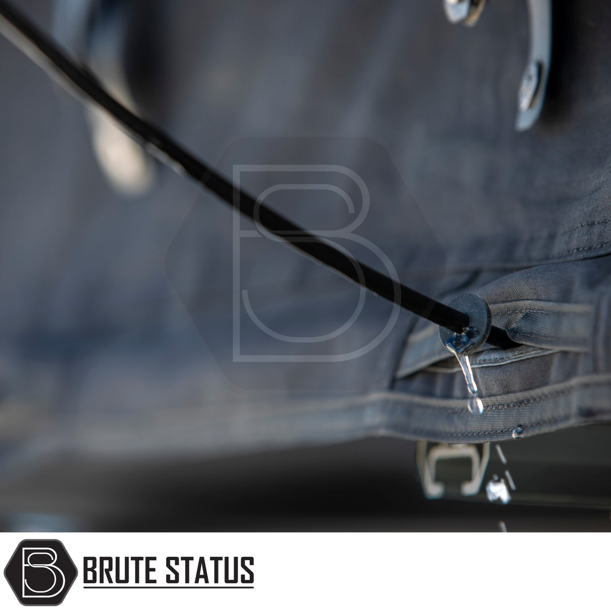 Grey fabric cover with a black drain tube and BRUTE STATUS logo, showcasing the ARB Esperance 2.0 Rooftop Tent's water-resistant design.