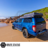 Blue Ford Ranger with ARB Flinders Rooftop Tent on a beach, showcasing off-road wheels and ARB canopy, highlighting overland touring setup.