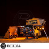 Brute Status ARB Flinders Rooftop Tent on 4x4 ute, pop-up tent, camp kitchen, under awning with chairs, showcasing compact, durable camping setup for two.