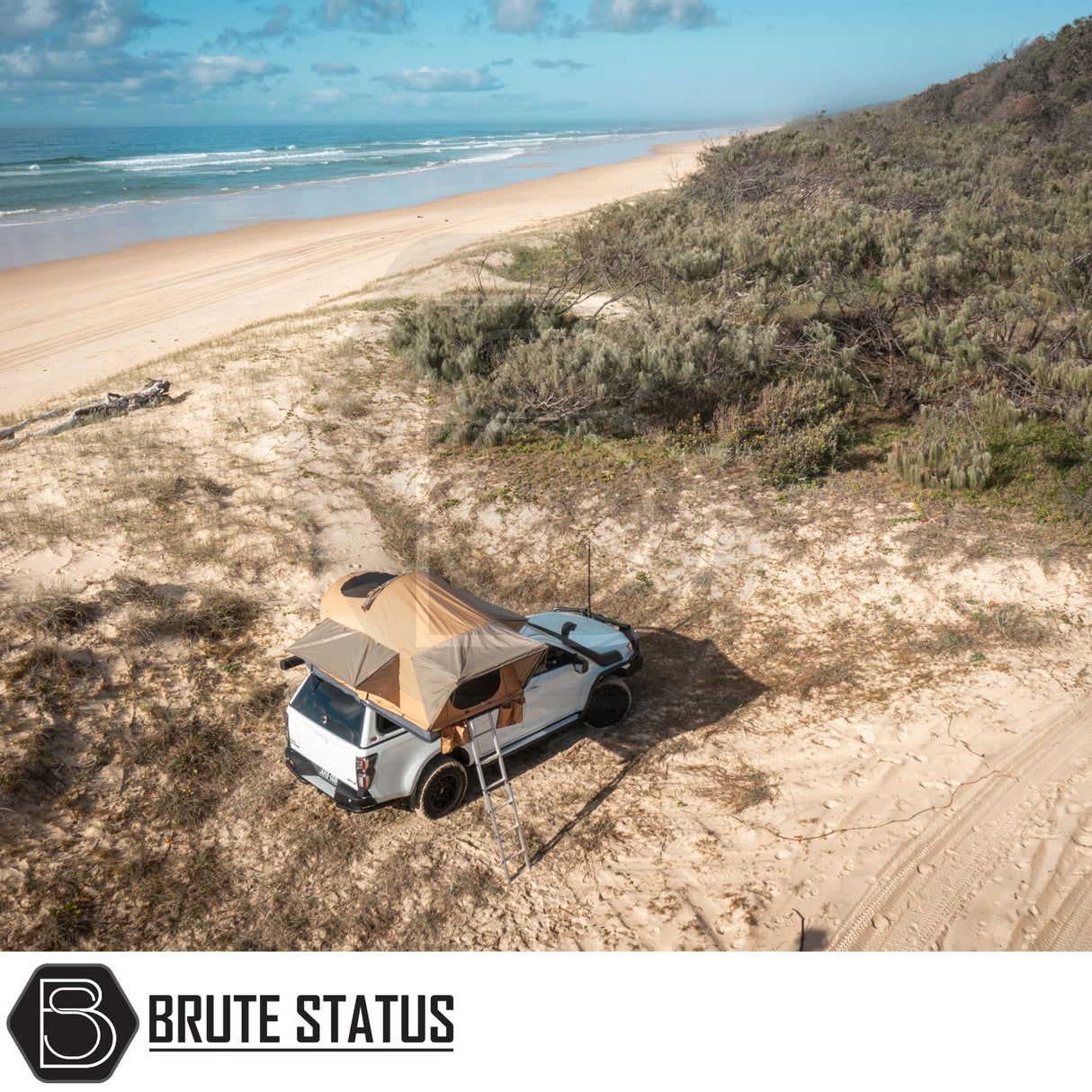 White pickup with ARB Flinders Rooftop Tent on sandy dunes; features fold-out design, access ladder, and compact, comfortable sleeping for two adults.