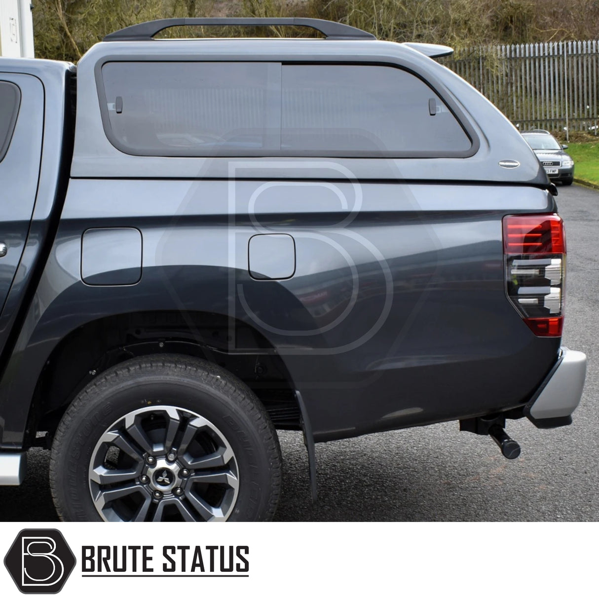 Rear view of a dark gray Mitsubishi L200 with Truckman GLS Hardtop Canopy featuring remote locking, tinted sliding windows, and tow hitch, ideal for enhanced storage and pet-friendly ventilation.
