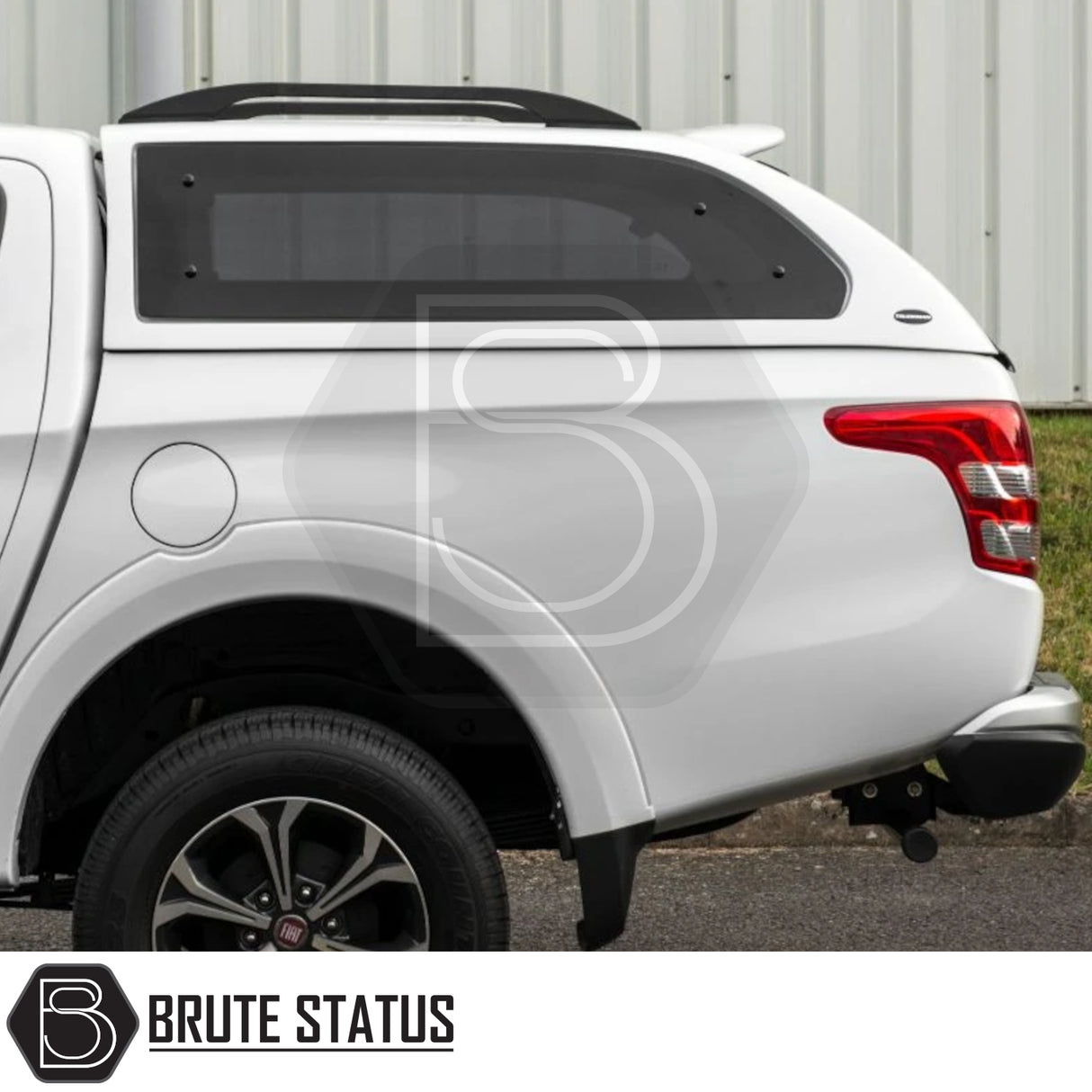 Rear-side view of a white pickup with Truckman Grand Hardtop Canopy, featuring tinted pop-out windows and roof rails for Fiat Fullback/Mitsubishi L200 Series 5-6.