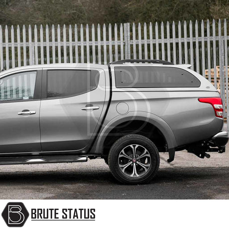 Silver Fiat Fullback/Mitsubishi L200 with Truckman Grand Hardtop Canopy, side view showing tinted windows, side-step, and branded canopy in a sleek, streamlined design.