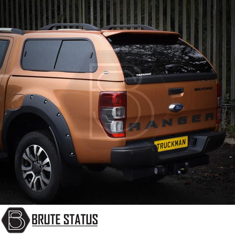 Metallic orange Ford Ranger with Truckman GLS Canopy, featuring remote locking, roof bars, tinted windows, and aftermarket fender flares, enhancing utility and style.
