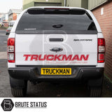 Ford Ranger 2012-2022 Truckman Grand Hardtop Canopy with remote locking, showcased on a white pickup, featuring TRUCKMAN branding, parked by a workshop.