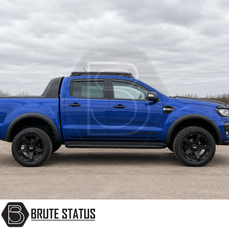 Smooth matte black ABS plastic wheel arch kit fitted onto blue Ford Ranger pickup truck offroad 4x4 vehicle. 