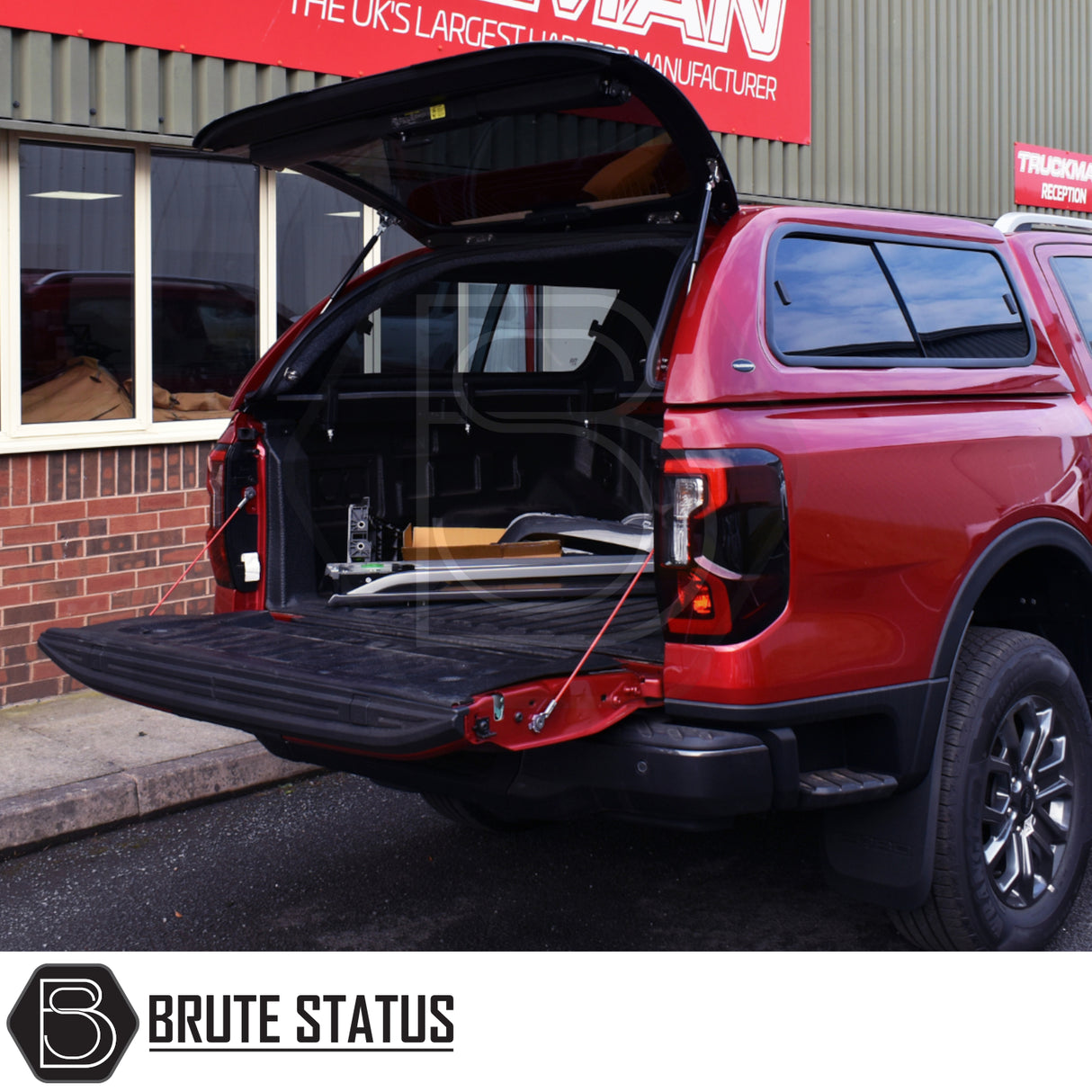Ford Ranger 2023+ T9 Truckman GLS Hardtop Canopy with remote locking, open tailgate, showcasing enhanced storage and ventilation features, parked at a workshop.