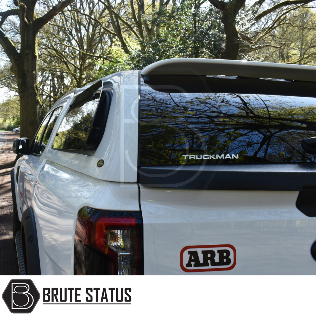 Ford Ranger 2023+ T9 Truckman Grand Hardtop Canopy with remote locking, featuring tinted windows and ARB sticker, parked under trees.