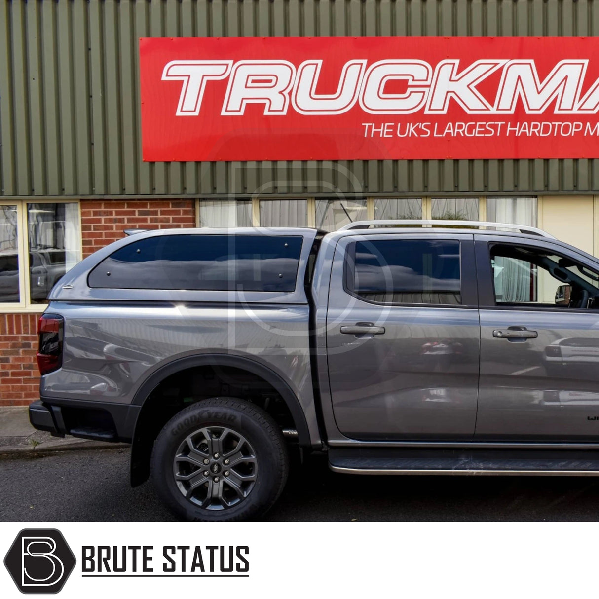 Grey Ford Ranger 2023+ with Truckman Grand Hardtop Canopy, featuring remote locking, parked by a Truckman sign, showcasing stylish design and enhanced storage.