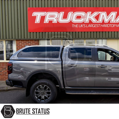 Grey Ford Ranger 2023+ with Truckman Grand Hardtop Canopy, featuring remote locking, parked by a Truckman sign, showcasing stylish design and enhanced storage.