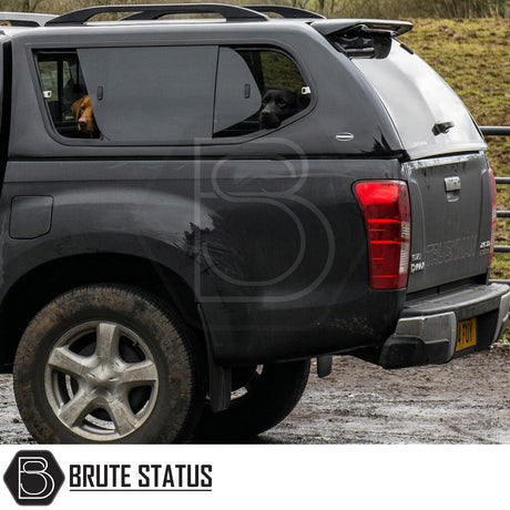 Isuzu D-Max 2012-2021 Truckman GLS Hardtop Canopy with dogs in sliding windows, showcasing remote locking and roof bars on a black pickup truck.
