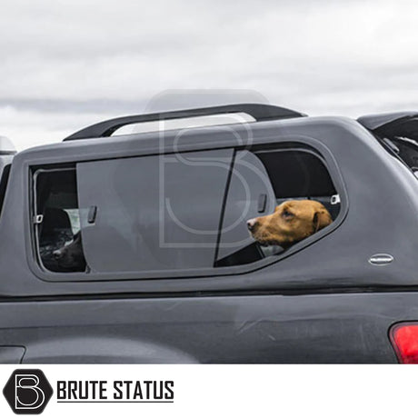 Pickup truck with a Brute Status branded Truckman GLS hardtop canopy, featuring an open sliding window, with a dog's head poking out for ventilation.