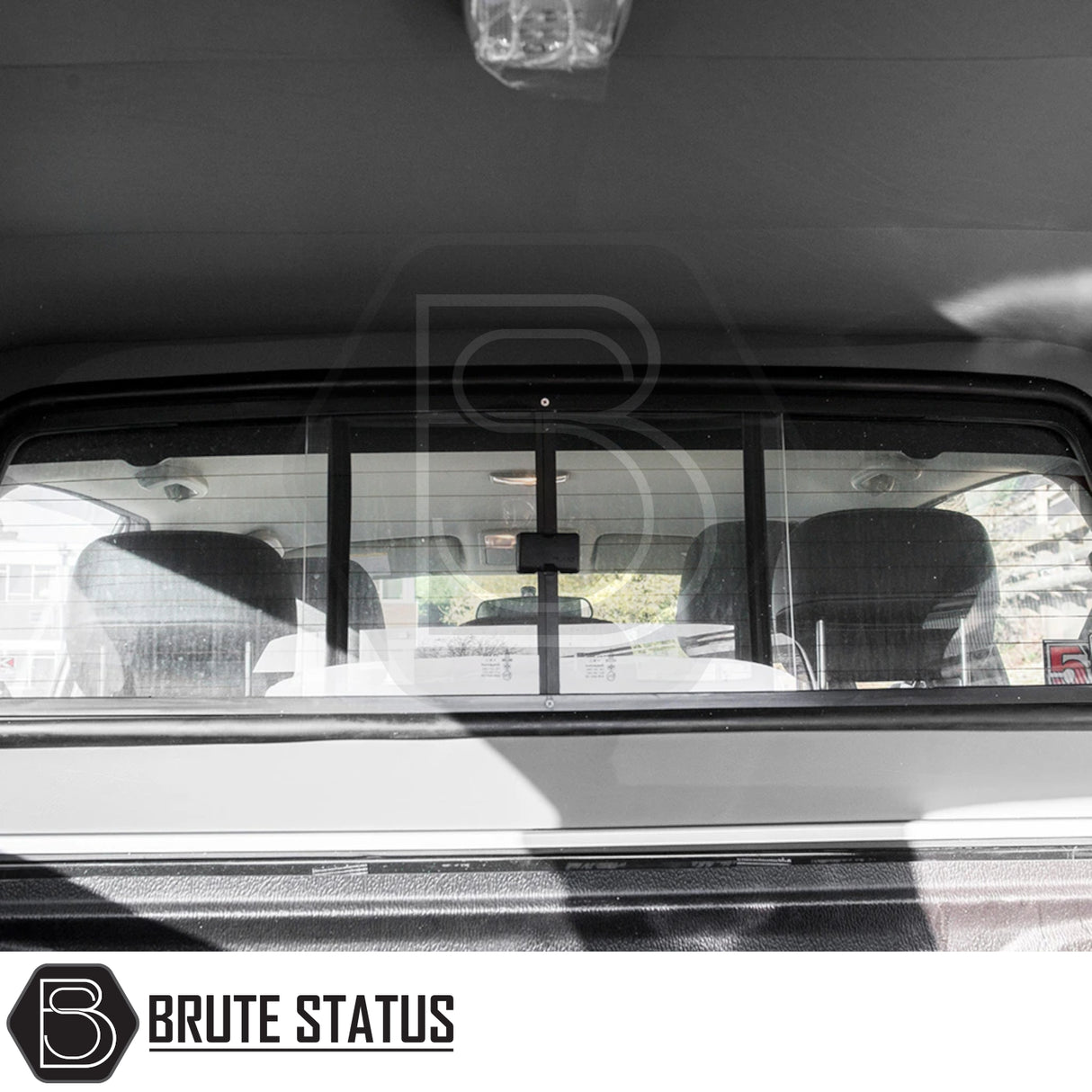 Rear view of Isuzu D-Max 2012-2021 Truckman Grand Hardtop Canopy, showcasing sliding bulkhead window and interior details from truck bed perspective.
