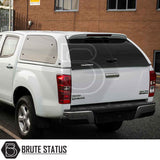 Isuzu D-Max 2012-2021 Truckman Grand Hardtop Canopy with tinted windows and remote locking, enhancing the truck's functionality and style against a brick building backdrop.