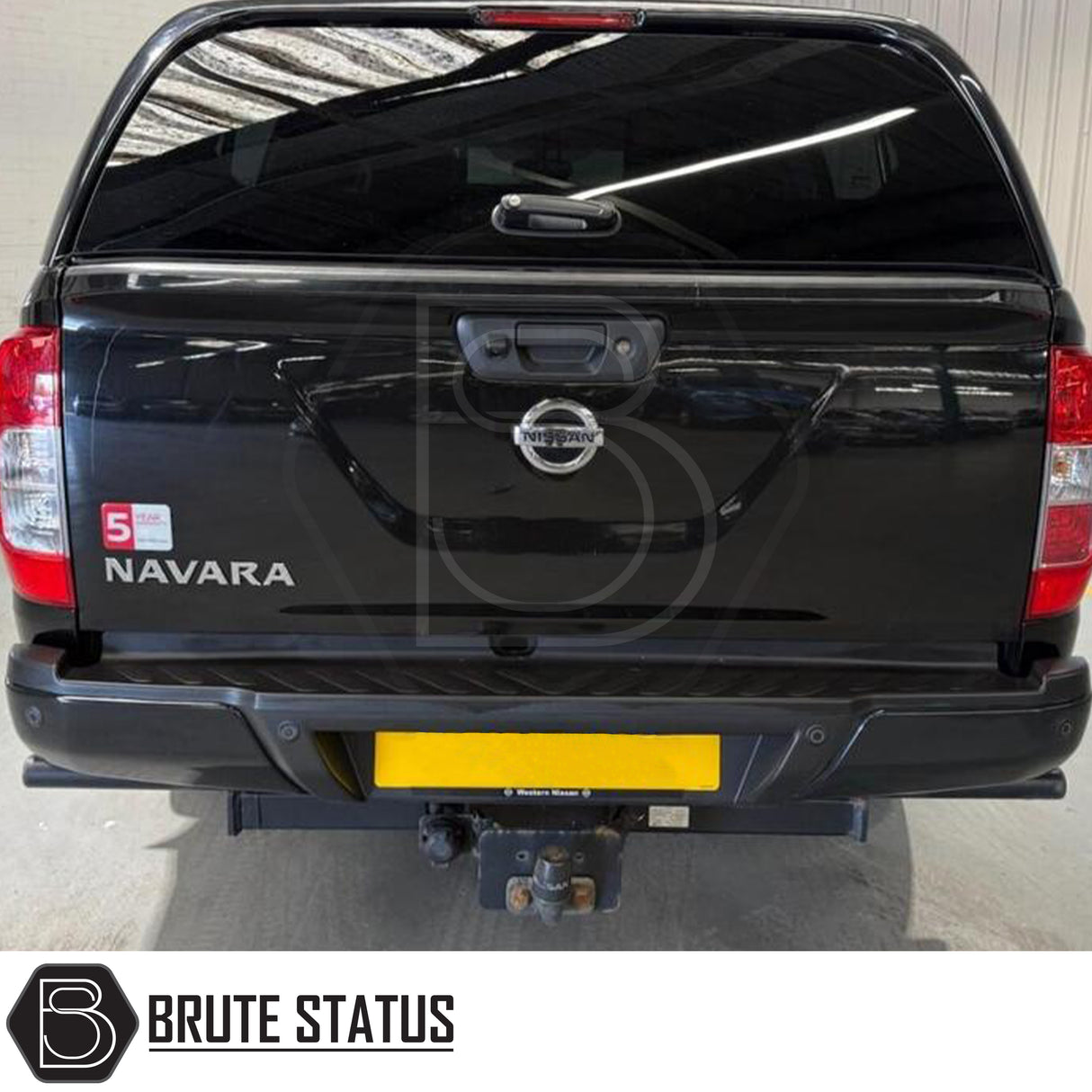 Black rear bumper for Nissan Navara NP300 (2015–2022), featuring a sleek factory-style finish, pre-drilled holes for OEM parking sensors, non-slip foot steps with drainage channels, and a durable, direct bolt-on design for easy installation and rugged use