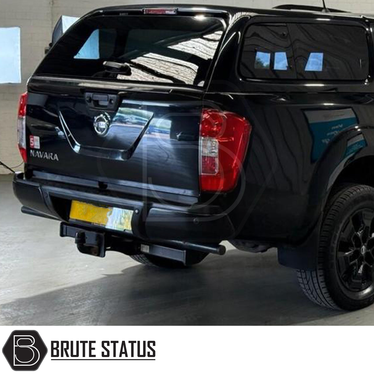 Black rear bumper for Nissan Navara NP300 (2015–2022), featuring a sleek factory-style finish, pre-drilled holes for OEM parking sensors, non-slip foot steps with drainage channels, and a durable, direct bolt-on design for easy installation and rugged use