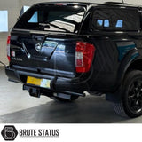 Black rear bumper for Nissan Navara NP300 (2015–2022), featuring a sleek factory-style finish, pre-drilled holes for OEM parking sensors, non-slip foot steps with drainage channels, and a durable, direct bolt-on design for easy installation and rugged use
