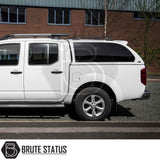 White Nissan Navara D40 with Truckman Grand Hardtop Canopy featuring remote locking, tinted windows, and pop-out side windows, parked on a street.