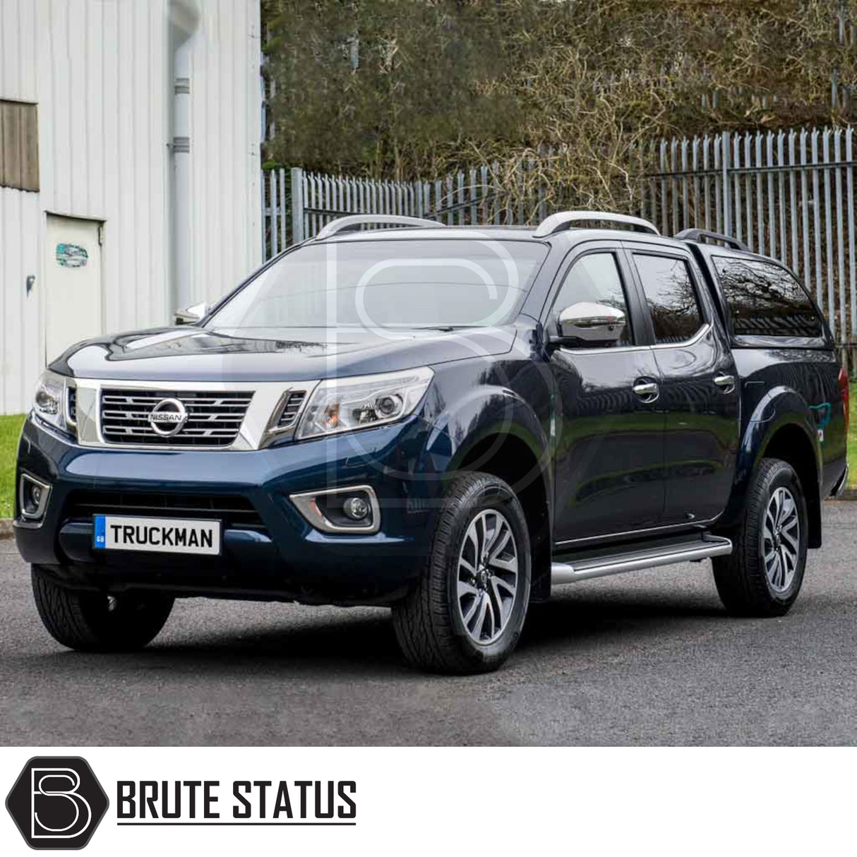 Nissan Navara 2005-2015 D40 Truckman Grand Hardtop Canopy with remote locking, featuring cab-high design, tinted windows, and roof rails, parked outside an industrial fence.