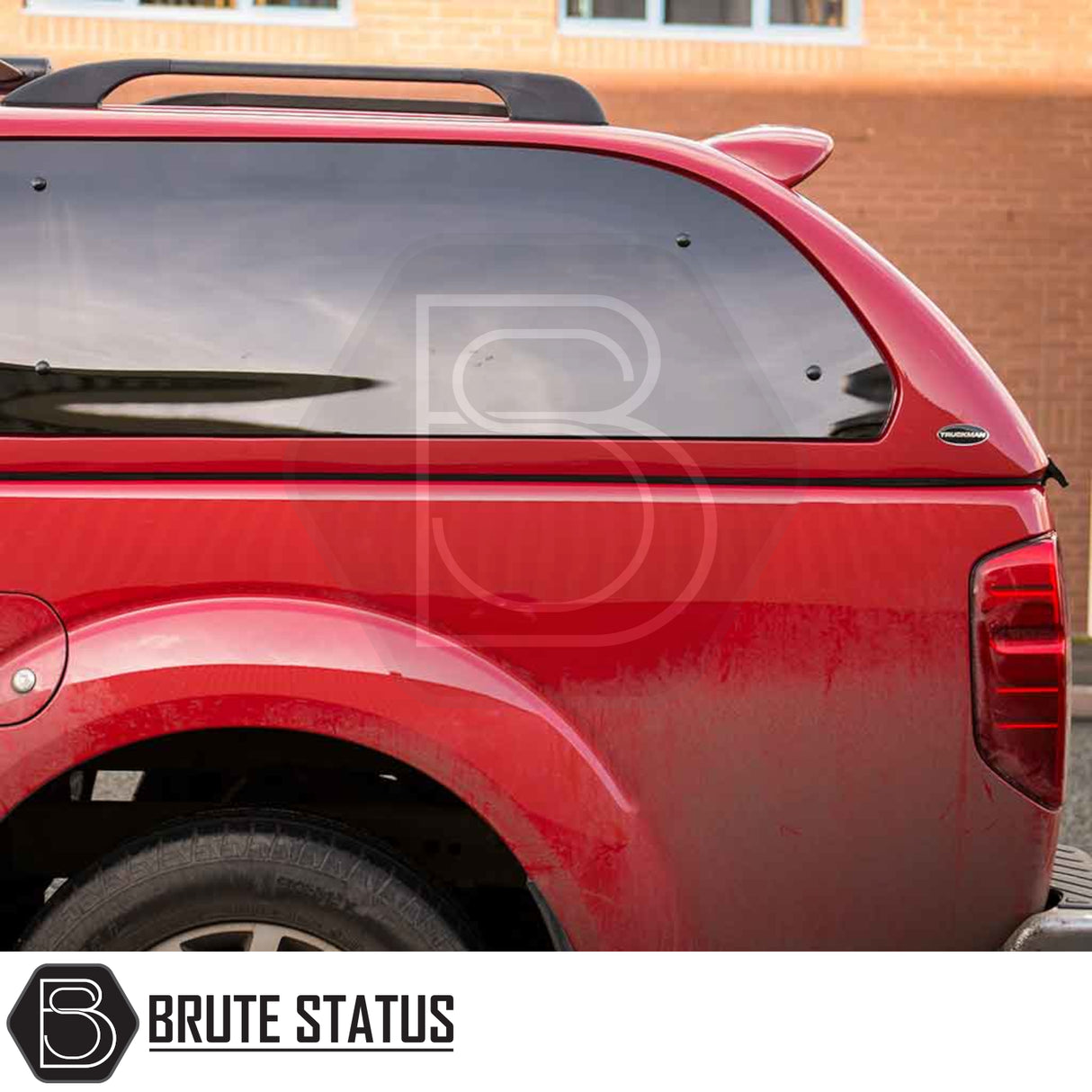 Nissan Navara pickup with Truckman Grand hardtop canopy featuring tinted side window and roof-rack bar, showcasing enhanced storage and security features.