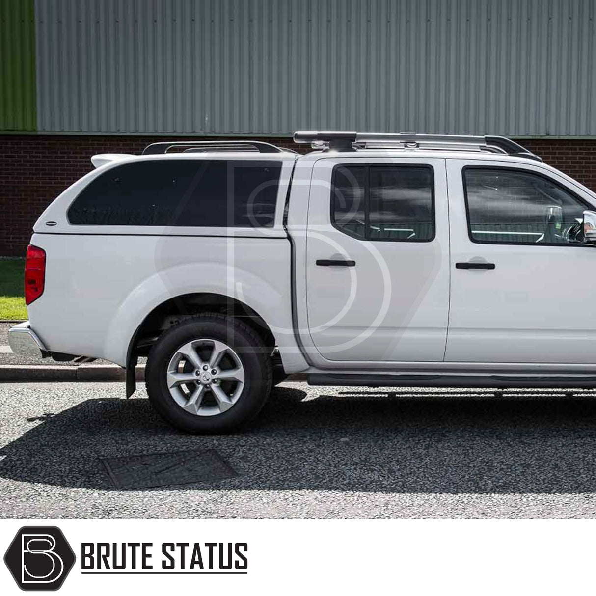 White Nissan Navara 2005-2015 D40 with Truckman Grand Hardtop Canopy featuring remote locking and tinted pop-out windows, parked on a street.