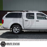 White Nissan Navara 2005-2015 D40 with Truckman Grand Hardtop Canopy featuring remote locking and tinted pop-out windows, parked on a street.