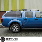 Side view of a blue Nissan Navara 2005-2015 D40 Truckman Grand Hardtop Canopy with remote locking, showcasing tinted windows and roof-rack rails.
