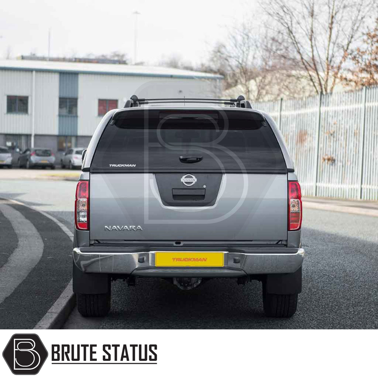 Silver Nissan Navara with Truckman Grand Hardtop Canopy, showcasing rear view with “NAVARA” and “TRUCKMAN” branding, parked on an urban street.