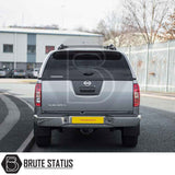 Silver Nissan Navara with Truckman Grand Hardtop Canopy, showcasing rear view with “NAVARA” and “TRUCKMAN” branding, parked on an urban street.