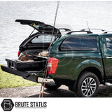Nissan Navara 2015-2023 NP300 Truckman Grand Hardtop Canopy open, showcasing a sliding cargo drawer with outdoor gear, against a lake backdrop.