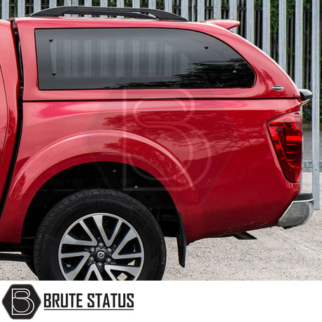 Rear view of a red Nissan Navara 2015-2023 NP300 with Truckman Grand Hardtop Canopy featuring tinted side window and alloy wheel, showcasing Brute Status accessory.