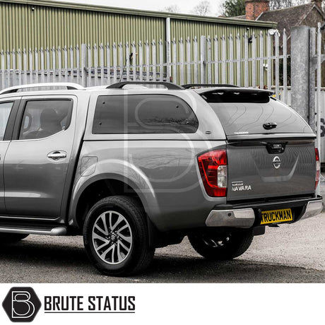 Nissan Navara 2015-2023 NP300 Truckman Grand Hardtop Canopy with remote locking, featuring a stylish design and tinted windows, parked by a metal fence.