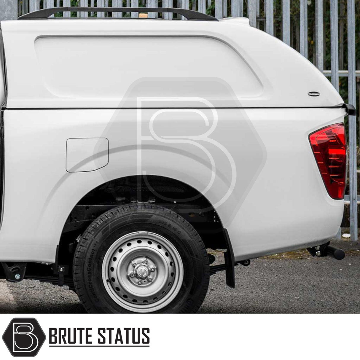 Nissan Navara 2015-2023 NP300 Truckman L-Series Hardtop Canopy with remote locking, rear-quarter view showing solid-sided design and roof rack against a metal fence.