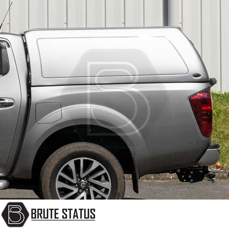 Silver Nissan Navara with Brute Status Truckman RS Hardtop Canopy, featuring alloy wheel, tow hitch, and glazed rear window for enhanced security and remote locking.