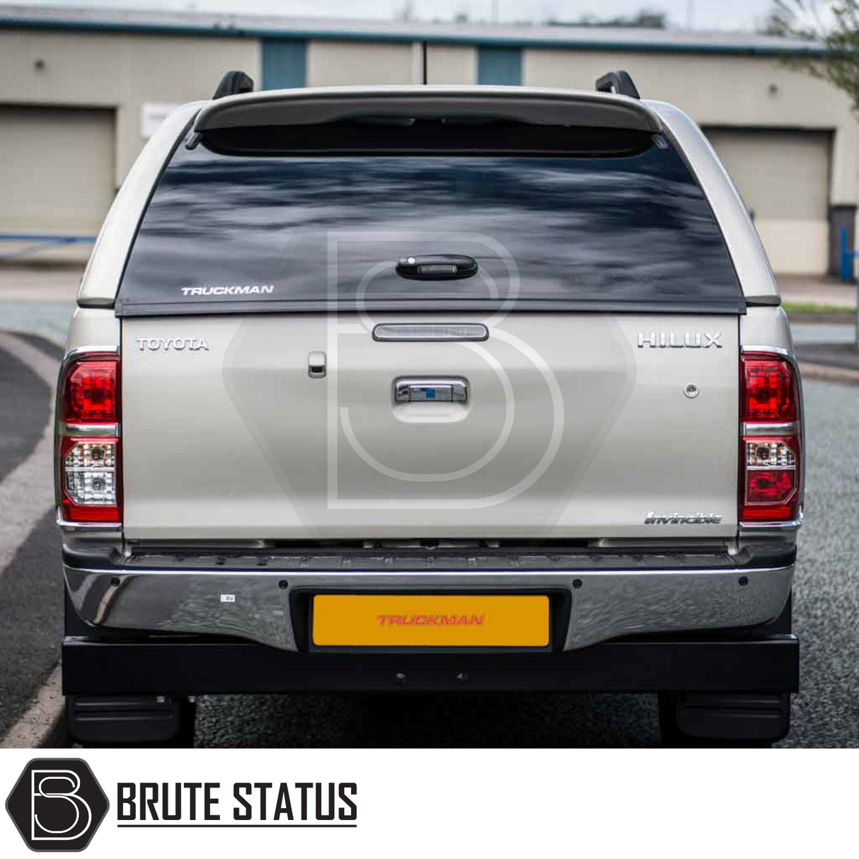 Silver Toyota Hilux 2005-2016 with a Truckman Grand Hardtop Canopy featuring tinted windows and remote locking. Tailgate showcases Toyota, Hilux, and Truckman logos.