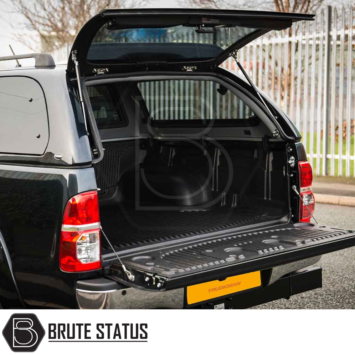 Toyota Hilux 2005-2016 Truckman Grand Hardtop Canopy with remote locking, open rear hatch, showcasing textured bed-liner and Brute Status logo.