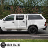 Toyota Hilux 2005-2016 with Truckman Grand Hardtop Canopy, featuring pop-out tinted windows and remote locking, parked with Brute Status logo visible.