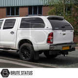 Toyota Hilux 2005-2016 with Truckman Grand Hardtop Canopy, featuring remote locking and tinted windows, parked in front of a commercial building.