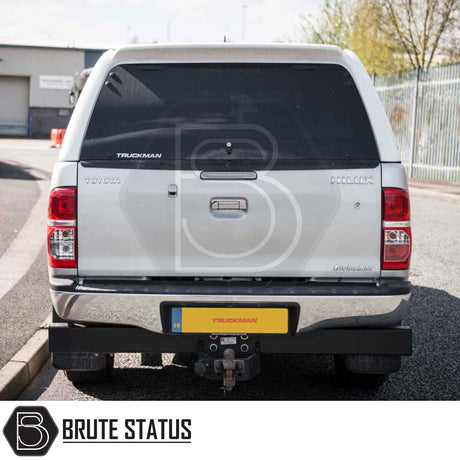 Rear view of silver Toyota Hilux with a Truckman RS Hardtop Canopy, featuring a glazed rear window and tow hitch, showcasing enhanced security and durability.