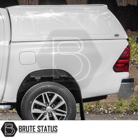 Toyota Hilux 2016+ MK8, MK9 Truckman RS Hardtop Canopy with solid rear window, showcasing a white fiberglass design, alloy wheel, and Brute Status logo.