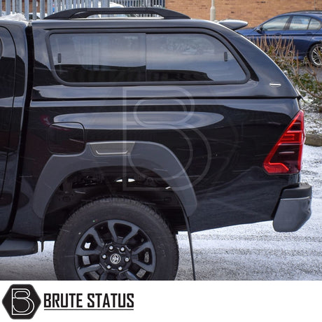 Toyota Hilux Invincible X 2016+ MK8, MK9 Truckman GLS Hardtop Canopy with remote locking on a black pickup, featuring tinted windows and a vinyl-lined interior.