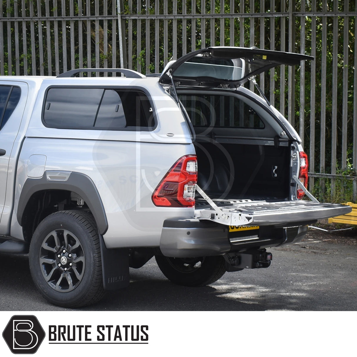 Toyota Hilux Invincible X with Truckman GLS hardtop canopy; rear hatch open, showing empty truck bed. Features remote locking and stylish, secure design for enhanced utility.