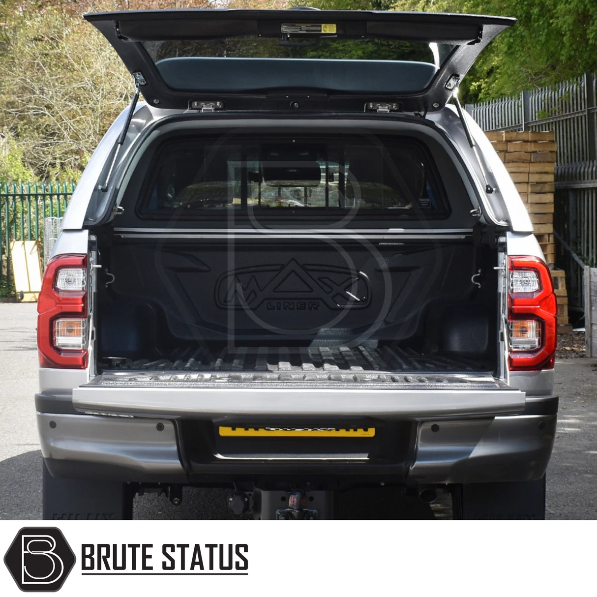 Toyota Hilux Invincible X 2016+ Truckman GLS Hardtop Canopy with open tailgate, featuring lockable sliding windows and molded liner, enhancing truck's sporty, secure storage.