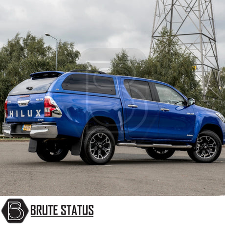Toyota Hilux Invincible X with Truckman Grand Hardtop Canopy, featuring remote locking, tinted windows, and pop-out side windows, parked on a paved surface.
