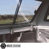 View from a pickup's bed showing a Volkswagen Amarok 2010-2022 Truckman GLS Hardtop Canopy with sliding rear window and aftermarket tonneau-cover rail.